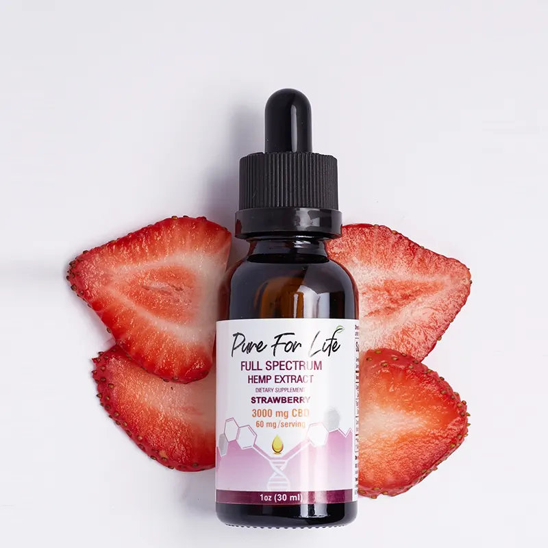 Strawberry CBD extracted tincture in a glass bottle and some red strawberry behind it