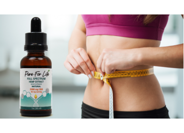A bottle with cannabidiol product nest to a happy woman measuring her waist