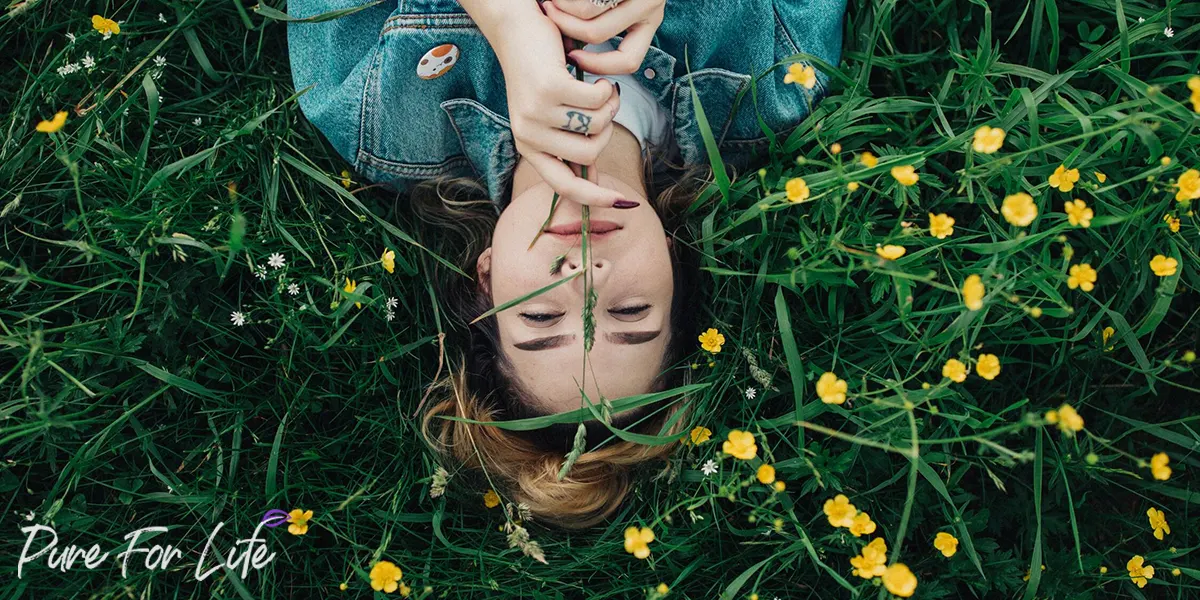 Rejuvenated woman lying on a meadow with flowers
